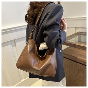 Dettaglio della borsa hobo marrone vintage in pelle con trama naturale e forma a mezzaluna