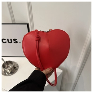 Détail du sac à bandoulière rouge en forme de cœur en cuir brillant avec fermeture éclair