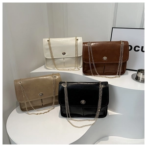 Detail of four retro style flap bags with gold chains and glossy faux leather finish
