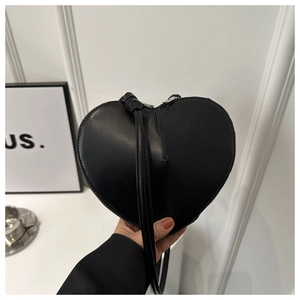 Gros plan du sac à bandoulière en cuir noir en forme de cœur avec finition lisse