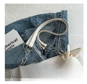 Détail du sac à bandoulière blanc texturé avec chaîne argentée et breloque lapin en peluche