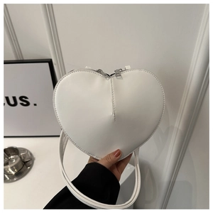 Vue détaillée du sac en cuir blanc en forme de cœur avec fermetures éclair argentées