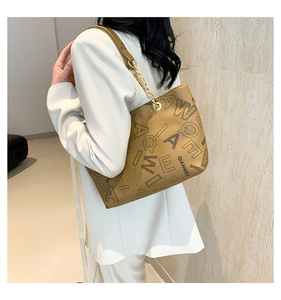 Chic mustard yellow tote bag with letter print and metal chain strap shown on model