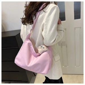 Borsa hobo rosa con ciondolo di peluche mostrata in un ambiente lifestyle casual