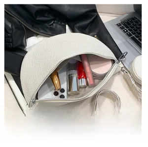 Internal storage display of white saddle bag showing phone and cosmetics capacity