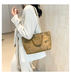Detail of vintage brown tote bag with letter print and golden chain strap for women