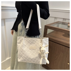 Détail du sac cabas matelassé blanc cassé avec bandoulière chaîne et breloque lapin