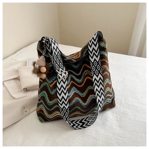 Detail of bohemian knit tote bag with wavy patterns and geometric wide shoulder strap