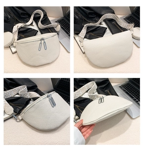 Detail view of white pebbled leather saddle bag with geometric wide strap and dual zippers