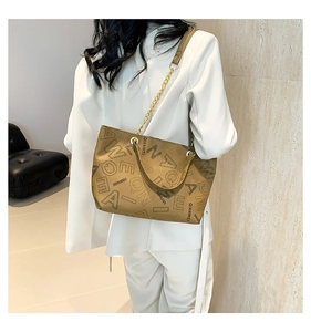Detail of khaki tote bag featuring gold chain strap and stylish letter print texture