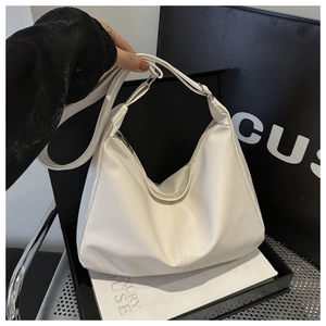 Dettaglio di una grande borsa hobo bianca con tracolla larga e trama in pelle liscia