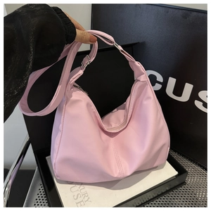 Dettaglio della borsa dumpling in nylon rosa chiaro con tracolla e fibbia in metallo argento