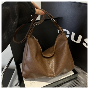 Vista dettagliata della texture della borsa hobo in pelle vintage marrone scuro e della zip
