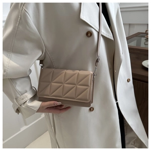 Detailansicht der khakifarbenen gesteppten Umhängetasche mit elegantem Trenchcoat