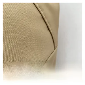 Macro detail of khaki nylon fabric showing twill weave texture and reinforced stitching