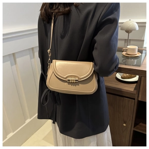 Détail d'un sac bandoulière abricot minimaliste avec fermoir tube doré élégant en cuir