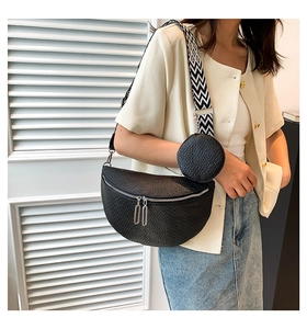 Black crescent saddle bag with geometric wide strap and small coin purse on a model