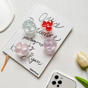 Detail of glittery heart phone socket stand set in four colors on a white book
