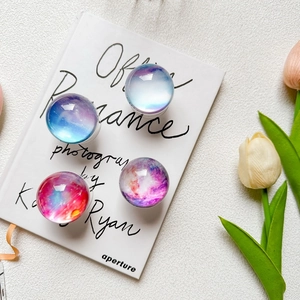Set of four celestial crystal ball phone socket grips with nebula galaxy designs