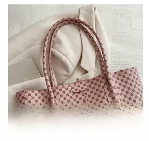 Détail d'un cabas rose vintage avec motif géométrique et poignées confortables