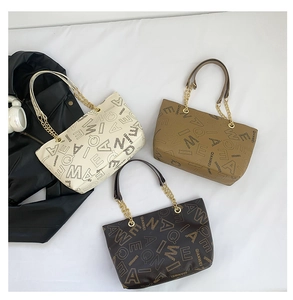 Detailed overhead shot of large vintage letter print tote bags in beige and brown tones