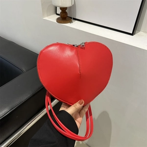 Fashionable red heart-shaped shoulder bag in glossy PU leather with silver zipper detail