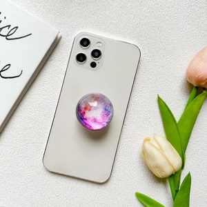 Purple galaxy nebula pattern collapsible cell phone grip on a white smartphone back