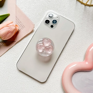 Sparkly glitter heart phone socket grip with pink 3D hearts on a white smartphone