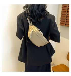 Close-up of beige nylon crossbody bag with woven zipper detail on a model in a black suit
