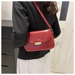 Mannequin portant un sac bandoulière en cuir rouge mat avec fermoir cylindrique doré