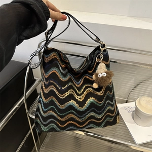 Knitted wave pattern bucket tote bag with leather handle and monster pendant accessory