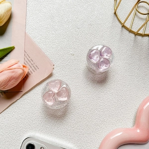 Detail view of heart-shaped glitter phone grips in pink and purple colors on a desk