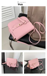 Detail of pink saddle bag featuring leather strap with gold buckle and smooth PU finish