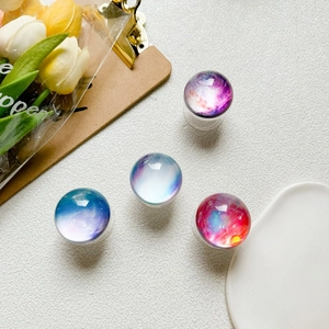 Detailed view of four colorful galaxy glass crystal ball phone grips in a stylish layout