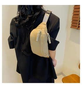 Detail of adjustable strap and buckle on a minimalist beige crossbody sports bag