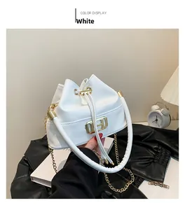 Detail der weißen Beuteltasche mit goldener H-Schnalle und elegantem Kettenriemen