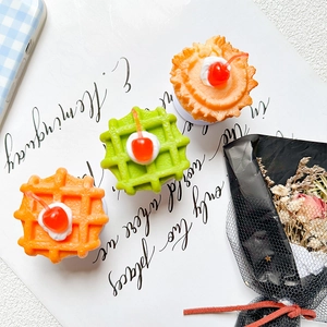 Cherry waffle and cupcake phone sockets with cream topping on a white base