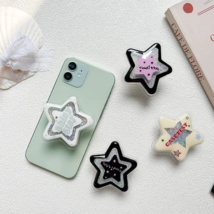 Glittery star-shaped expandable phone socket grip on smartphone with multiple color options