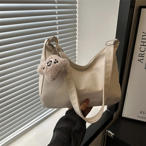 Borsa hobo beige minimalista in morbida pelle con un grazioso ciondolo a orsetto
