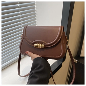 Détail du sac à rabat marron foncé avec fermoir doré et texture en cuir synthétique mat