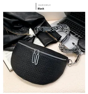 Detail of black pebbled leather crescent saddle bag with geometric woven shoulder strap