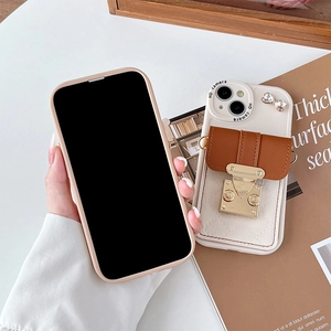 Cream iPhone wallet case with brown leather card slot, gold buckle and bow charm