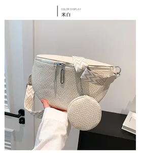 Detail of cream white lychee leather saddle bag with wide geometric strap and round coin pouch