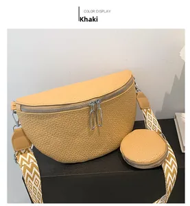 Detail view of khaki crescent bag with double zippers and patterned wide shoulder strap