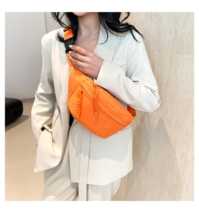 Detail of orange nylon sports fanny pack with textured strap and plastic buckle