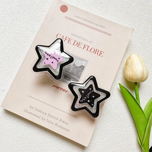 Detail of star-shaped glitter phone grips in pink and black on a French magazine