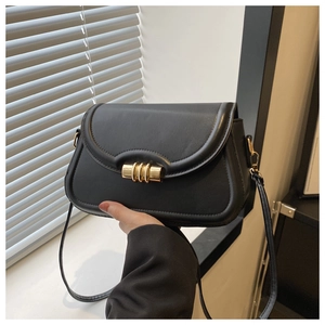 Détail d'un sac bandoulière en similicuir noir avec une boucle en métal doré à trois anneaux