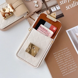 Detail of quilted leather crossbody phone case with card slots and gold metal clasp
