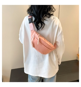 Pink nylon belt bag detail featuring color-matched zipper and black adjustable buckle