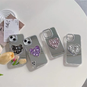 Detailed view of four mirror phone cases featuring sparkling heart-shaped gemstones